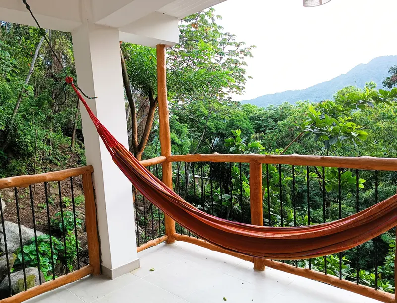 Hamaca en la terraza con vista al bosque y a las montañas